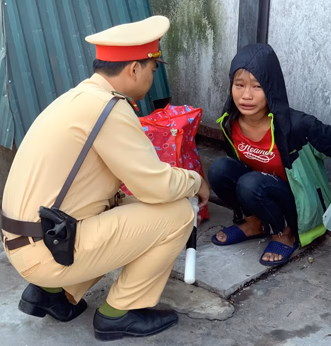 Đại úy Tạ Xuân Hậu thăm hỏi bé gái.