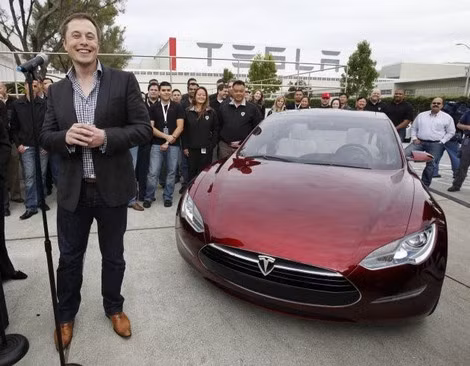 Ông Elon Musk bên cạnh một mẫu xe điện của Công ty Tesla.