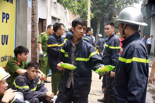 Lực lượng cứu hộ chia nhau ăn vội chiếc bánh mì cho bữa trưa.