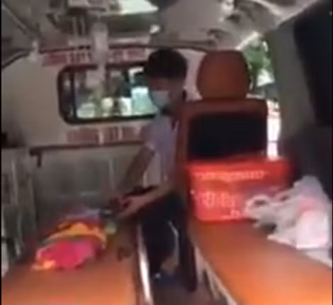 Bệnh nhi trong xe đang được nhân viên y tế bóp bóng thở.