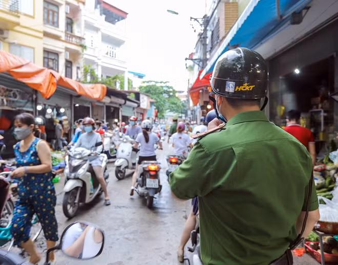 Lực lượng chức năng liên tục nhắc nhở mọi người giãn cách, đeo khẩu tranh phòng dịch.