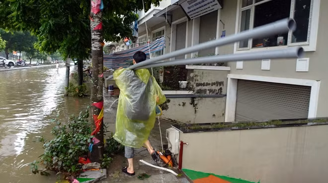 Trước tình trạng ngập sâu, nước tràn vào nhà, người dân tại đây phải huy động máy bơm, nối thêm đường ống nước để bơm hết nước khỏi các căn hầm bị ngập.