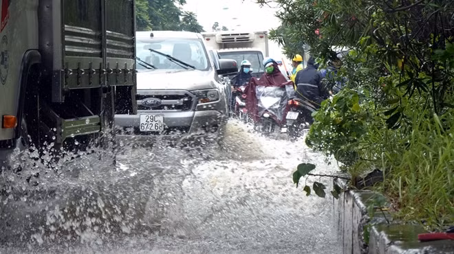 Khi không còn lựa chọn nào khác, nhiều tài xế ô tô lẫn người đi xe máy buộc phải lao qua điểm ngập sao cho nhanh nhất. Hình ảnh những chiếc ô tô đi qua đây tạo ra những đợt sóng hay bắn nước văng ra xung quanh.