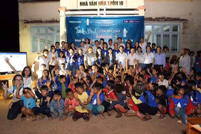Các em nhỏ hồ hởi khi được cấm trên tay chiếc đèn chiếu sáng bằng năng lượng mặt trời từ Chương trình Tết An Bình lần thứ 11 trao tặng