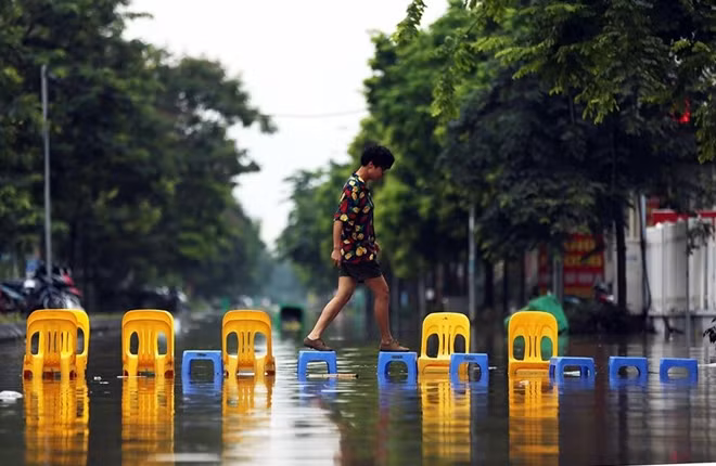 Các nhà hàng tại điểm ngập lụt khu đô thị mới Lê Trọng Tấn - Geleximco, Hà Đông, Hà Nội. đã phải bắc ghế cho khách ra vào sau trận mưa lụt nghiêm trọng tháng 7.2018. Ảnh: Nam Nguyễn
