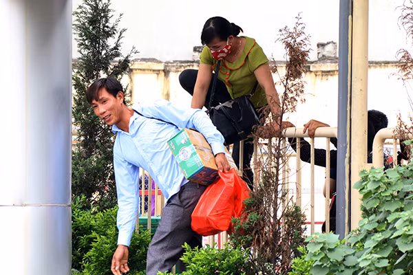 Chứng kiến cảnh lối vào bến xe ken đặc người, nhiều người đã chọn giải pháp "vượt rào" vào thẳng bãi đỗ xe.