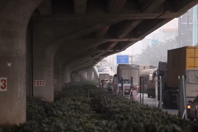 Cách đó không xa, đường Vành đai 3, tuyến giao thông huyết mạch của thủ đô Hà Nội cũng ngày một đông đúc các phương tiện giao thông. Xe tải, container chạy rầm rập theo hàng dài trên đường. Tuyến đường này hiện đang được công nhân rào chắn để thi công mở rộng lòng đường.