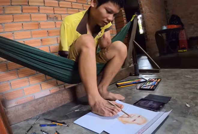 Nguyễn Văn Tây miệt mài vẽ tranh bằng chân.