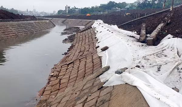 Vị trí sạt lở tại Công trình Kè chống sạt lở suối Hội Phú đang được phủ bạt trắng.