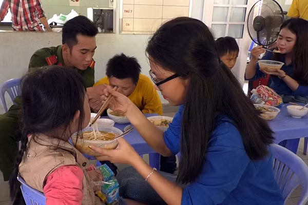 Thành viên đoàn công tác chăm sóc các em nhỏ ở trung tâm.