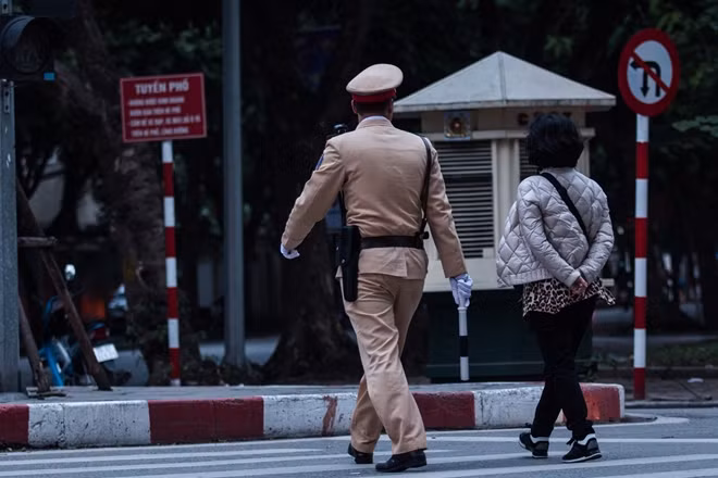 Chiến sỹ CSGT đưa một người phụ nữ qua đường.