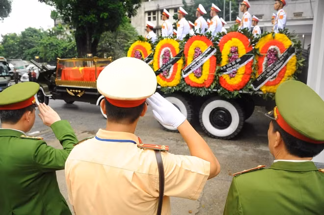 Những chiến sỹ công an làm nhiệm vụ đảm bảo an ninh tại lễ tang nghiêm trang giơ tay chào linh cữu Chủ tịch nước.