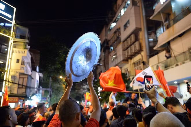 Đi cùng với hình ảnh rực rỡ của phố phường là âm thanh sống động từ những... chiếc xoong nồi được trưng dụng làm đạo cụ cổ vũ bóng đá