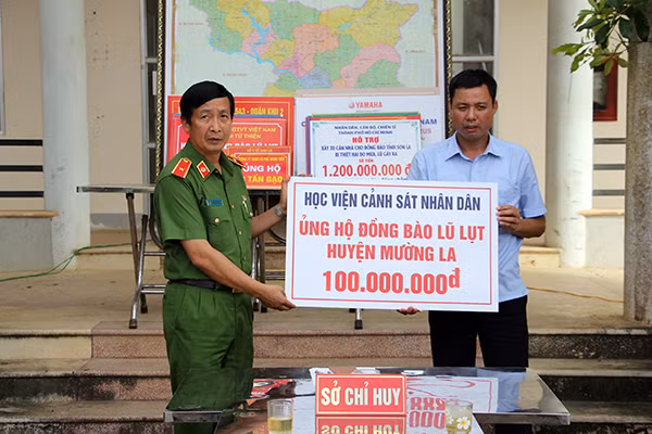 Thiếu tướng Nguyễn Văn Nhật - Phó Giám đốc Học viện CSND trao 100 triệu đồng cho quỹ phòng chống thiên tai, giúp đỡ nhân dân huyện Mường La, tỉnh Sơn La khắc phục khó khăn sau lũ.