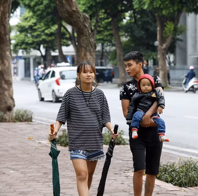 Nhiều gia đình trẻ cũng tranh thủ tiết trời se lạnh đầu tiên của Hà Nội để đi ngắm cảnh phố phường, trẻ em được bố mẹ mặc ấm trước khi ra đường.