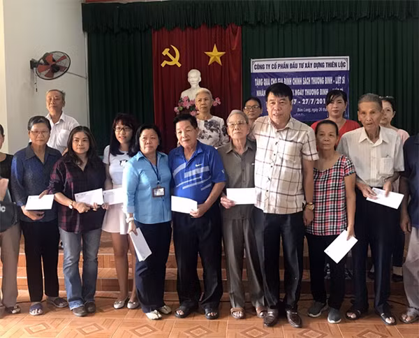Chủ tịch UBND phường Bửu Long (TP Biên Hòa) Lê Thị Thu Tâm và ông Vũ Văn Trường trao quà cho các gia đình người có công trên địa bàn