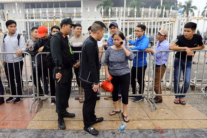 Một người phụ nữ tìm cách chen ngang vào hàng chờ mua vé bị CSCĐ ngăn chặn và nhắc nhở.