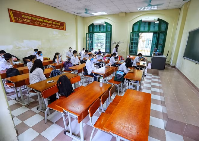 Phía trong lớp học, Ban giám hiệu trường Chu Văn An đã bố trí các em học sinh ngồi giãn cách nhau, mỗi bàn chỉ 1 em để đảm bảo an toàn phòng dịch.