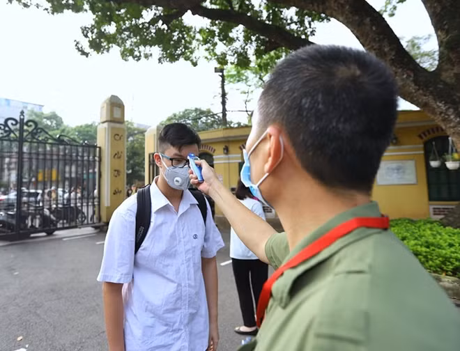 Công tác đo thân nhiệt được thực hiện nghiêm tục ngay cổng vào trường.