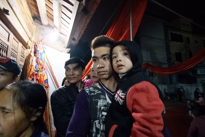 Trẻ nhỏ cùng người lớn trong làng ngóng chờ giây phút "xin đỏ" lấy may.