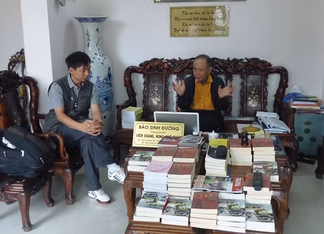 Thầy giáo Phùng Hoàng Anh (bên trái) trong một lần đi sưu tầm sách.