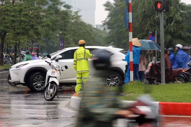 Lực lượng CSGT vất vả điều tiết giao thông trong mưa.