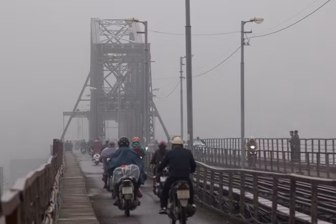 Người dân lưu thông qua cầu Long Biên trong làn sương mù vào lúc 7h sáng.