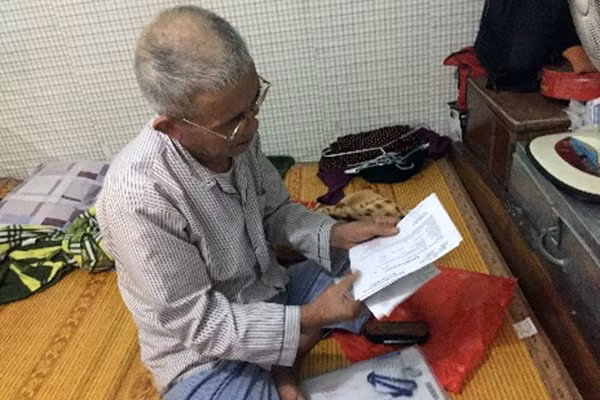 Ông Dương Xuân Chiên với tập hóa đơn tiền thuốc.