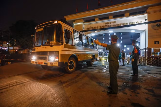 Đoàn xe chở người nhà bệnh nhân lên khu cách ly tập trung rời bệnh viện Bạch Mai.