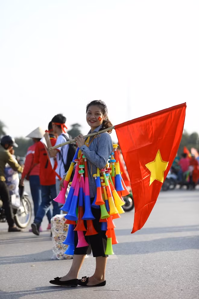 Cô gái trẻ thu hút được rất nhiều ánh nhìn của người đi đường với vô số chiếc kèn cổ động treo trên người.