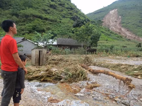 Bố con anh Đào Bình Dình thất thần trước trận lũ quét lịch sử vừa tràn qua thôn Tùng Nùn.