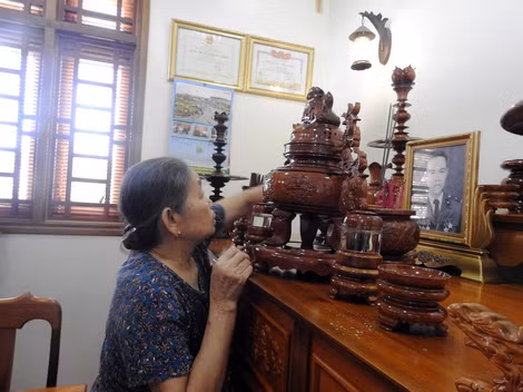 Bà Huê thắp hương cho chồng.