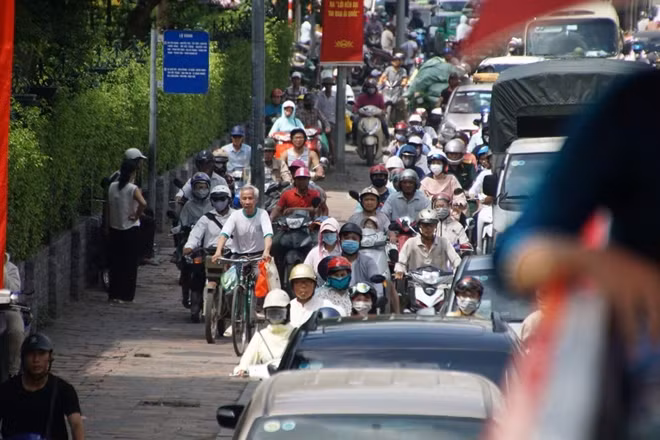 Chờ đợi vì tắc đường quá lâu, người đi xe máy, xe đạp bắt đầu leo hè để tìm lối thoát