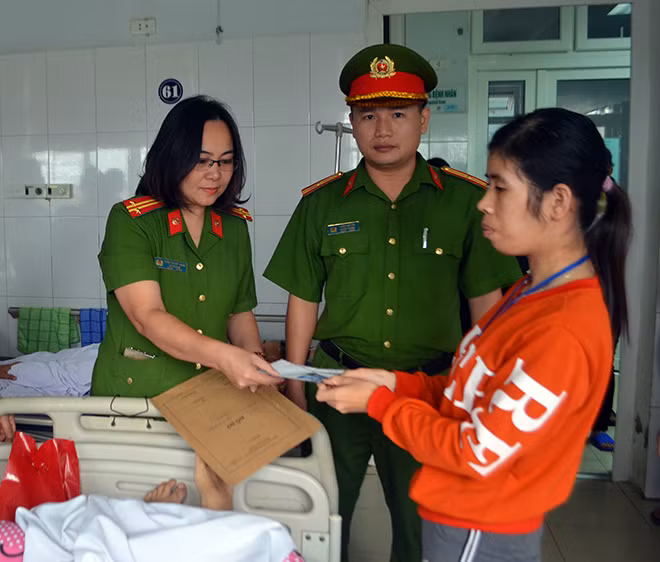 Cán bộ Phòng Cảnh sát Quản lý hành chính về trật tự xã hội Công an Nghệ An trao CMND và quà cho anh Đặng Khắc Thành.