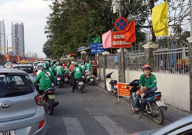 Mặc dù có biên cấm dừng, đỗ đón khách những cánh xe ôm vẫn túc trực phía bên ngoài cổng Bến xe Giáp Bát chờ đón những vì khách vừa xuống xe gây ra cảnh lộn xộn giao thông.