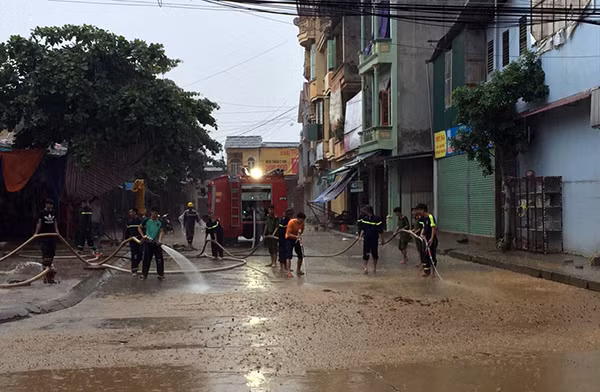 Cảnh sát PCCC Yên Bái phun nước rửa mặt đường bám đầy bùn đất.