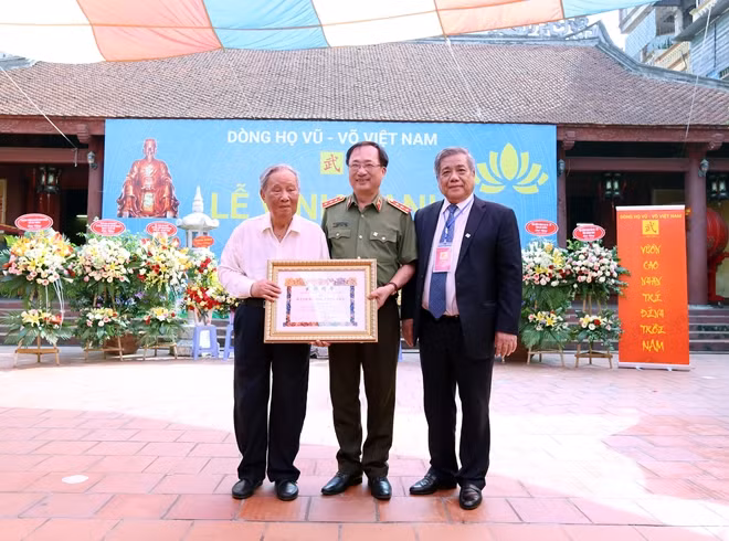 Cụ Vũ Oanh nhận bằng “Vũ tộc tinh hoa” và chụp ảnh lưu niệm với Thứ trưởng Nguyễn Văn Thành và Chủ tịch Hội đồng Dòng họ Vũ – Võ Việt Nam Vũ Minh Giang.