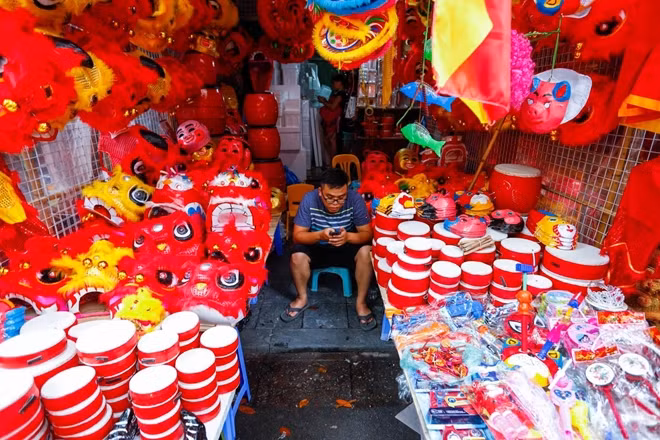 Một quầy hàng rực đỏ với các món đồ chơi Trung thu truyền thống như đầu lân, trống...