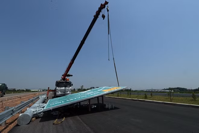 Công nhân tiến hành lắp đặt biển báo trên tuyến cao tốc.
