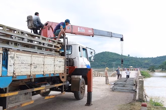 Lực lượng chức năng đang vận chuyển vật liệu để lắp cầu tạm tại cầu chữ V