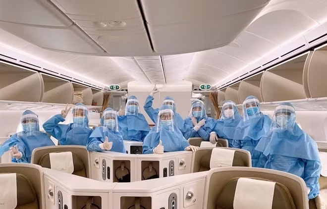 Các phi công, tiếp viên của Vietnam Airlines mặc trang phục bảo hộ trước khi thực hiện chuyến bay đến châu Âu, đón những hành khách từ vùng dịch COVID-19 trở về Việt Nam an toàn. Ảnh: VNA