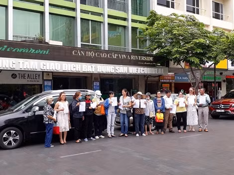 Các nạn nhân giăng biểu ngữ trước nơi được coi là văn phòng của Công ty Modern Tech.