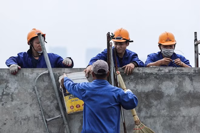 Phía bên ngoài tầng 18, công nhân đang khẩn trương lắp đặt giàn giáo.
