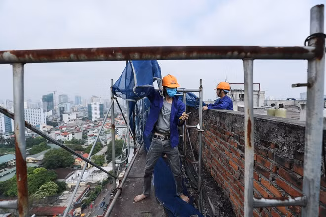 Cùng với giàn giáo, phần bạt che cũng được căng lên nhằm tránh cho vật liệu xây dựng sau khi phá dỡ rơi ra đường giao thông cũng như khu dân cư xung quanh.