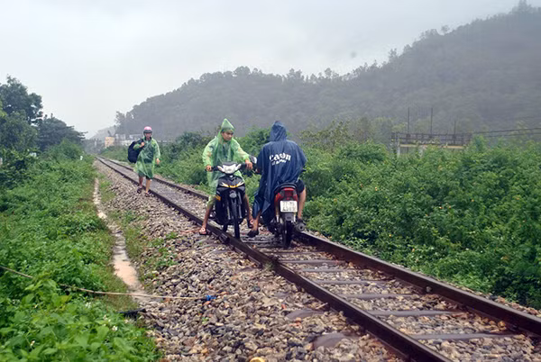 Tại TP.Quy Nhơn, một số người dân bất chấp nguy hiểm, điều khiển phương tiện trên đường ray tàu hỏa để vượt qua các đoạn đường bị ngập nước