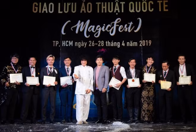 Chủ tịch Hội ảo thuật IMS Hoa Kỳ (áo trắng) trao bằng “thạc sĩ” ảo thuật cho những người tham gia chương trình.