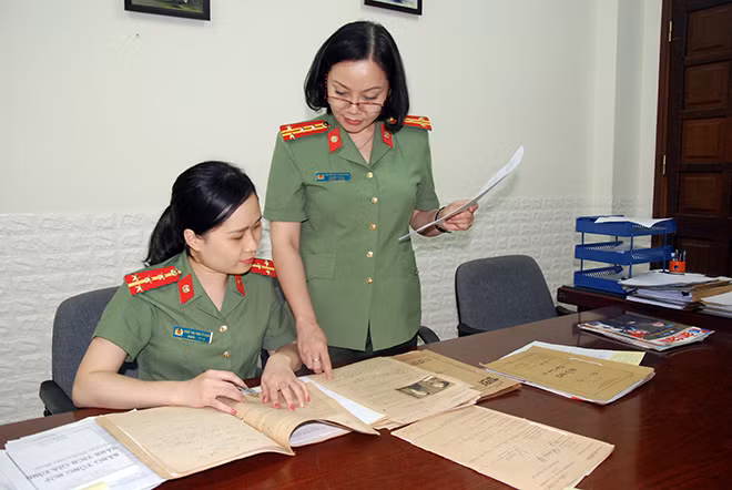 Đại tá Nguyễn Thị Thanh Nhàn hướng dẫn Đại úy Đào Thị Thu Trang tra cứu tài liệu bằng tiếng Pháp.