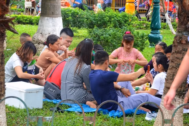 Hết đạp lên cỏ để chụp ảnh, nhiều người còn vô tư lấy luôn bãi cỏ làm nơi "tọa lạc" cho mình và gia đình thưởng thức đồ ăn.