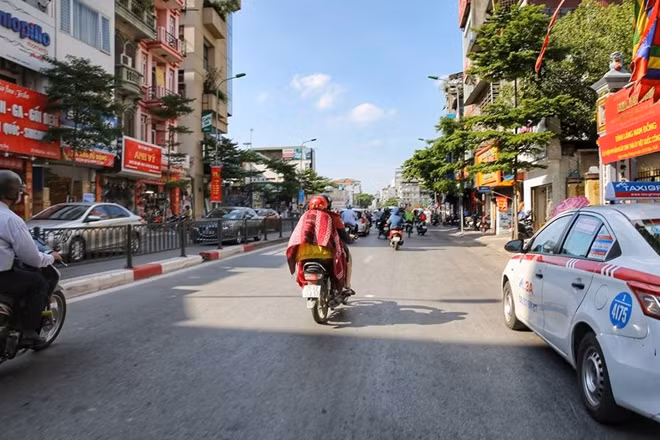 Với những người phải ra đường cũng có những cách rất riêng để chống lại nắng nóng. Như người phụ nữ trong ảnh với chiếc chăn mỏng vốn để giữ ấm vào mùa đông nay lại được trưng dụng để che nắng.