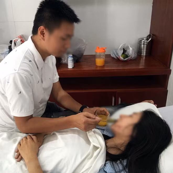 Nạn nhân được chồng chăm sóc tại bệnh viện.